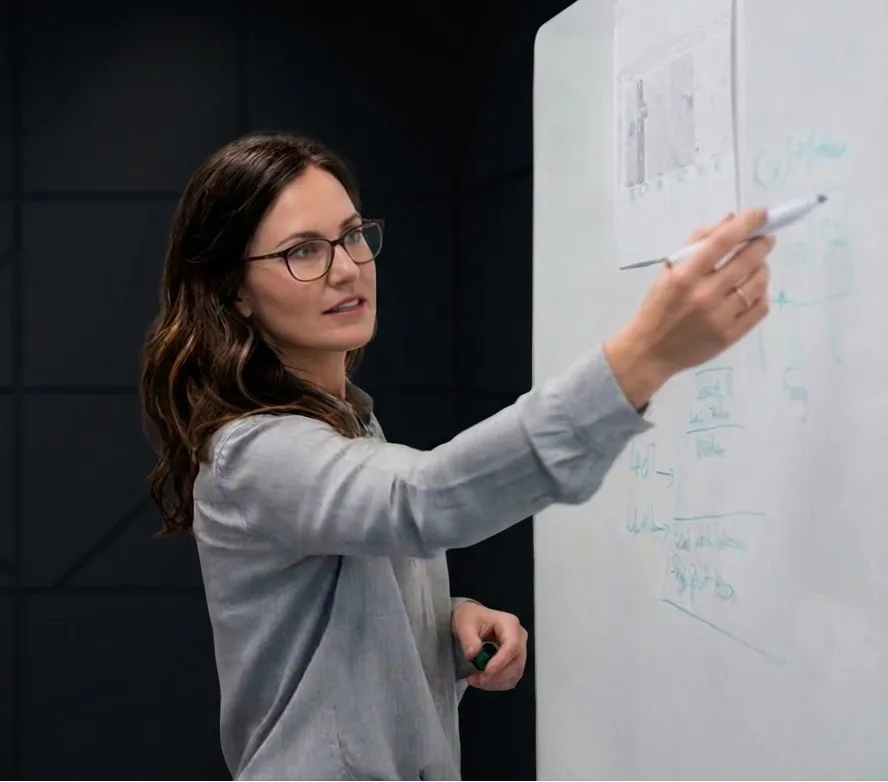 Profesora explicando en pizarra, modelo colaborativo SIGMA