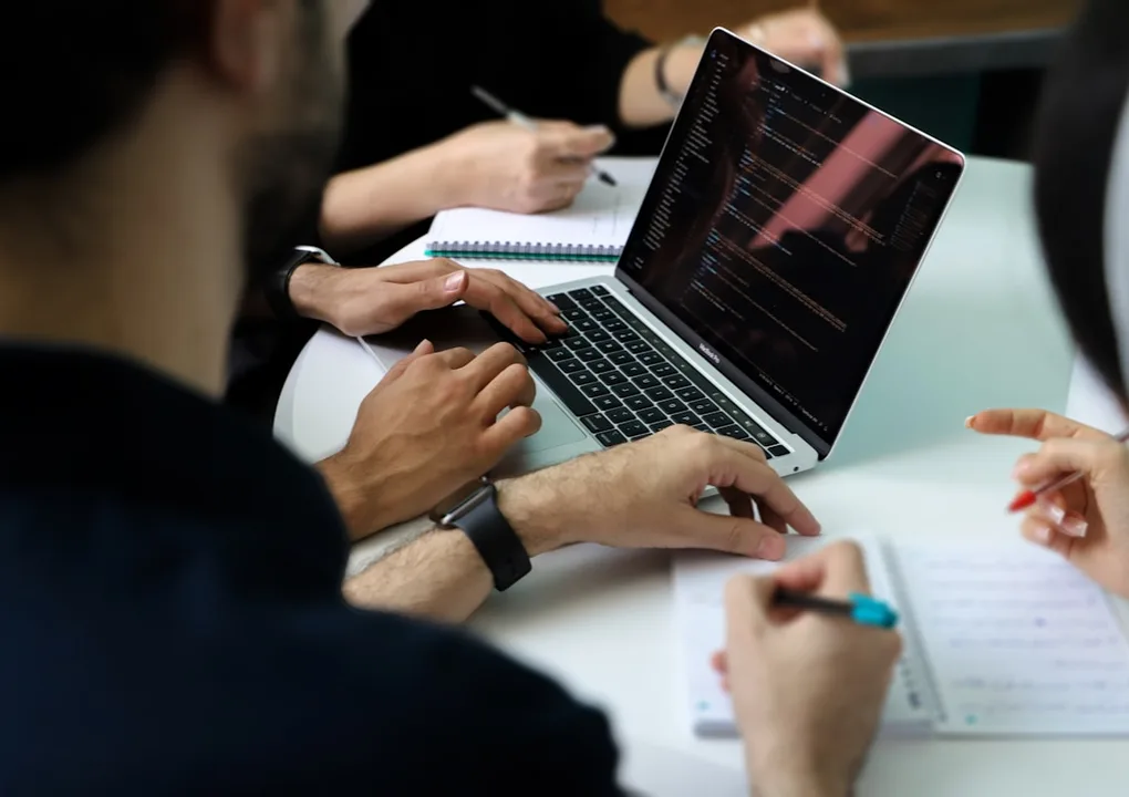 Equipo de gestión universitaria trabajando con un portátil, eficiencia y control con SIGMA