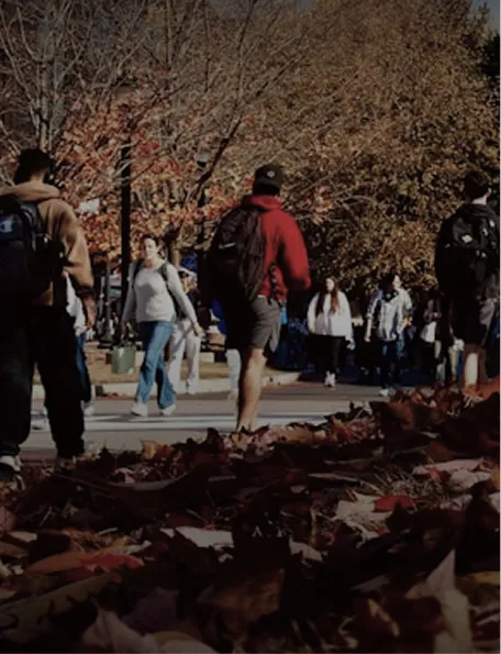 Estudiantes caminando por un campus en otoño, valor de progreso en comunidad